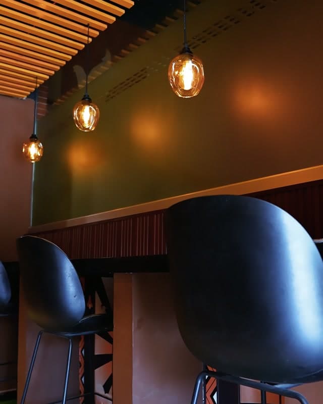 The Sufraq dining room in Gulshan-e-Iqbal, booths and pendant lamps under a wooden slat ceiling